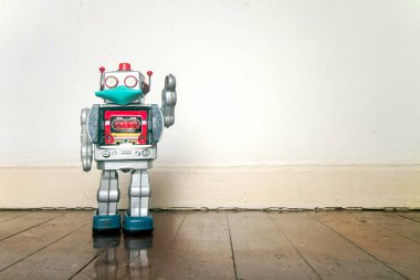 Eski ahşap bir zeminde maskeli retro robot oyuncağı 