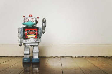Eski ahşap bir zeminde maskeli retro robot oyuncağı