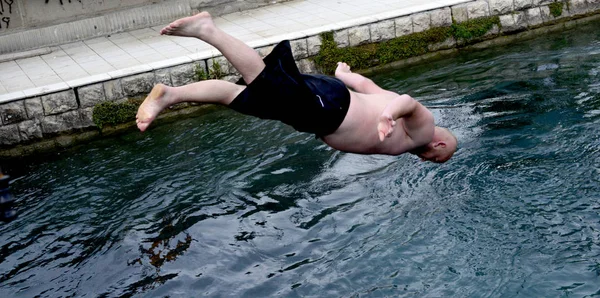 Struga, Makedonya - 17 Haziran 2018: Struga, Makedonya'nın Drim Nehri şehrin suya köprüden erkekler atlamak