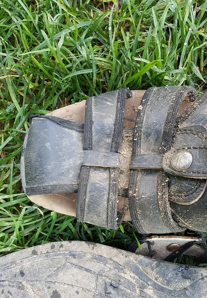 Smutsiga mannen sandaler på gräs bakgrund — Stockfoto