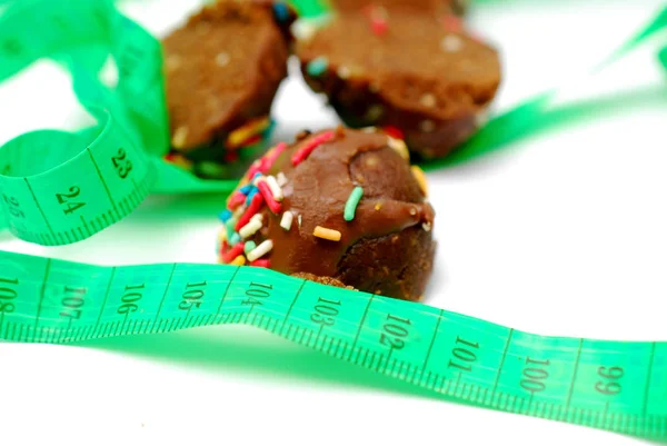 Homemade chocolate balls and tape measure on white background diet concept — Stock Photo, Image