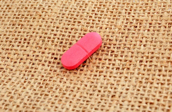 Nahaufnahme Von Rosa Pille Auf Einem Jutesack Hintergrund — Stockfoto