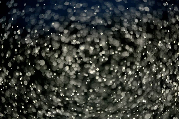 Repülő Vízcseppek Ellen Napsugarak Egy Sötét Háttér Kép — Stock Fotó