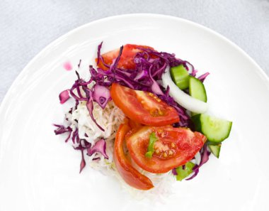 Beyaz tabakta taze salata, organik ve vejetaryen yemek temalı..