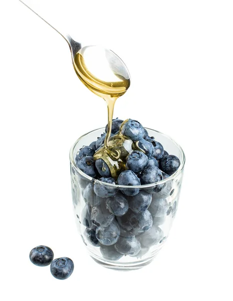 Ekşi bardakta taze yabanmersini ve bir kaşık bal.