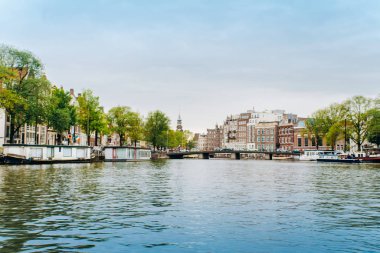 Amsterdam, Hollanda 5 Eylül 2017: Ağaçlar ve durgun su Amstel Nehri'nin, Amsterdam, Hollanda evleri, yansıması.