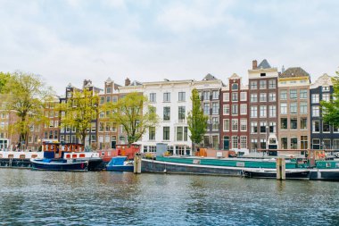 Amsterdam, Hollanda 5 Eylül 2017: Ağaçlar ve durgun su Amstel Nehri'nin, Amsterdam, Hollanda evleri, yansıması.