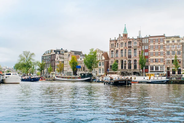 Amsterdam, Nederländerna 5 September 2017: Reflektion träd och hus i stilla vatten i floden Amstel, Amsterdam, Nederländerna. — Stockfoto