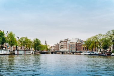 Amsterdam, Hollanda 5 Eylül 2017: Ağaçlar ve durgun su Amstel Nehri'nin, Amsterdam, Hollanda evleri, yansıması.