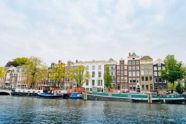 Amsterdam, Hollanda 5 Eylül 2017: Ağaçlar ve durgun su Amstel Nehri'nin, Amsterdam, Hollanda evleri, yansıması.
