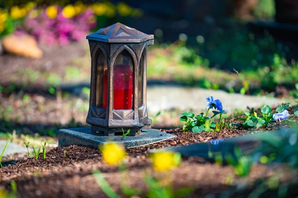 Czerwona świeca na nagrobki z kwiatami — Zdjęcie stockowe