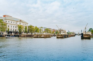 Amsterdam, Hollanda 5 Eylül 2017: Ağaçlar ve durgun su Amstel Nehri'nin, Amsterdam, Hollanda evleri, yansıması.