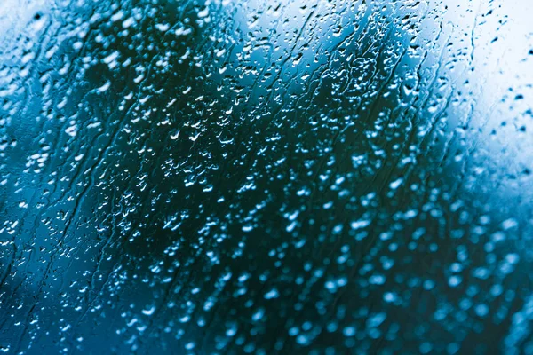 Gotas de chuva na janela fundo azul — Fotografia de Stock