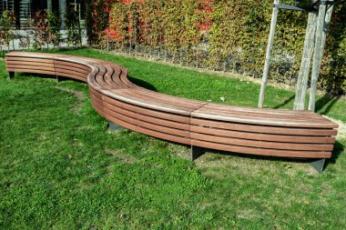 Güneşli bir günde, şehir parkında modern bir bank.