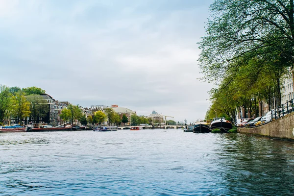 Amsterdam, Hollanda 5 Eylül 2017: Ağaçlar ve durgun su Amstel Nehri'nin, Amsterdam, Hollanda evleri, yansıması.