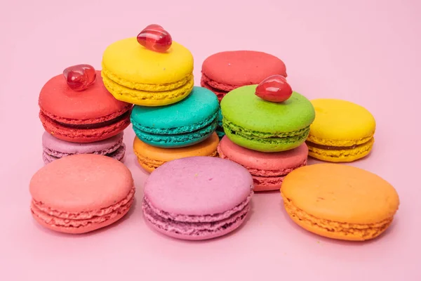 A lot of french colorful macarons on a pink background — Stock Photo, Image