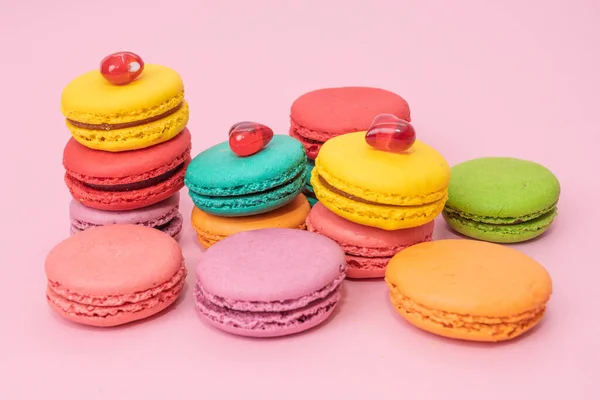 A lot of french colorful macarons on a pink background — Stock Photo, Image