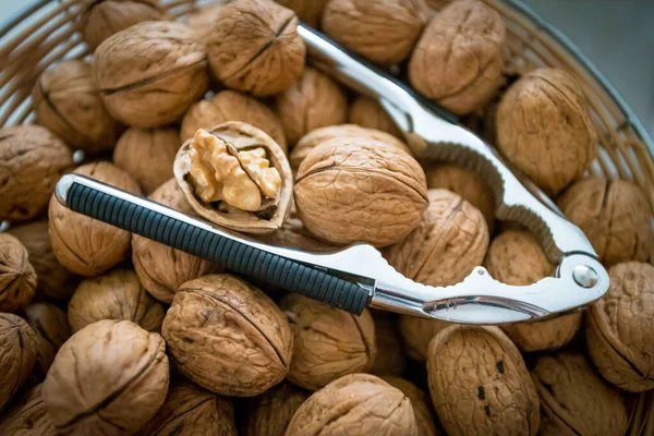 Nutcracker on brown walnuts. Whole walnuts — Stock Photo, Image