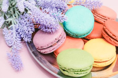 pembe arka planda lezzetli renkli makarnalar