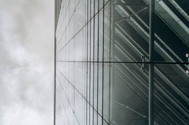 Bulutlu gökdelenlere karşı dramatik bir manzara. Aşağıdan gökdelenin görüntüsü