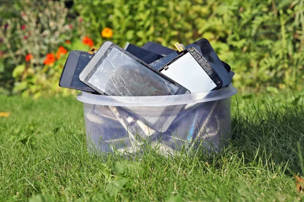 Куча Сломанных Потрескавшихся Сотовых Телефонов Пластиковой Коробке Лежат Зеленой Газонной — стоковое фото