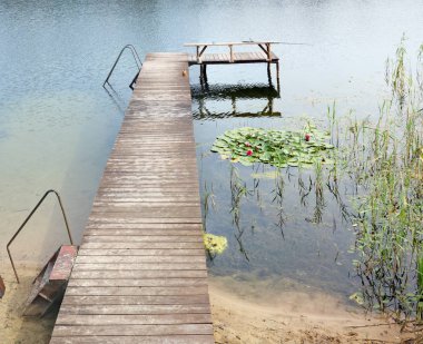 Bir tipik yaz bir göl ve ahşap iskele, Litvanya yatay tekneler için. Güneşli bir gün açık atış