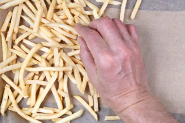 Yaşlı bir adam şeritler patates bir fırın tepsisine dışarı atarken aşçıdır. Bu Fransızca et pişirme süreci başlıyor. Stüdyo üstten görünüm vurdu