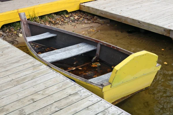 Bir ahşap kırık el yapımı yaşlı tekne soğuk taze Gölü su rıhtımın üzerinde kullanılır. Avrupa sonbahar açık atış