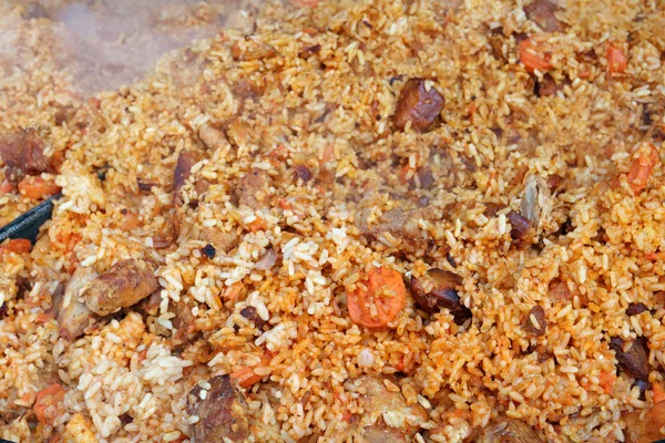 Fast street food - hot Asian pilaf with meat and carrot. Appetizing background