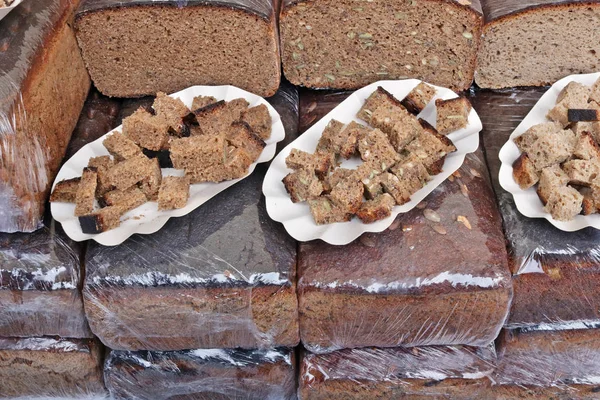 Large pieces of Lithuanian rustic rough rye black bread are sold — Stock Photo, Image