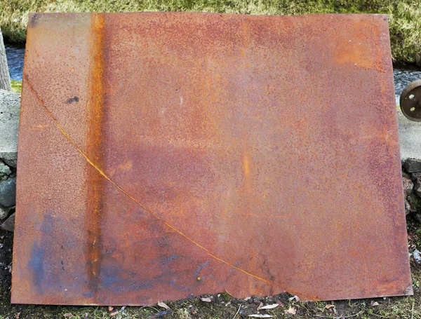 Μεγάλο σκουριασμένο φύλλο σιδήρου σε μια ρουστίκ αυλή — Φωτογραφία Αρχείου