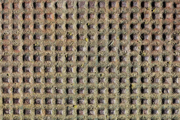 Muitos buracos quadrados artesanais na folha vintage enferrujada de ferro — Fotografia de Stock