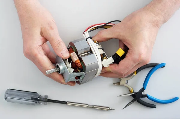 Régi idősek otthoni kézműves javítások az elektromos motor a MiNC — Stock Fotó