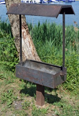 Bir metal paslı barbekü ızgara t çimenli kıyısında monte edilmiştir