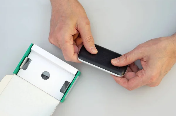 Old man grandpa  unpacks new mobile phone — Stock Photo, Image