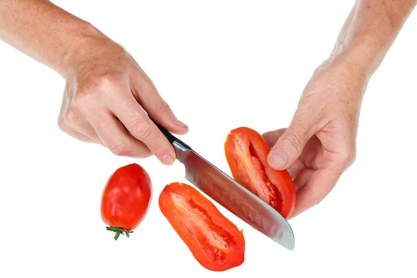 年老いた先輩女性が赤いトマトを手に持って切る — ストック写真