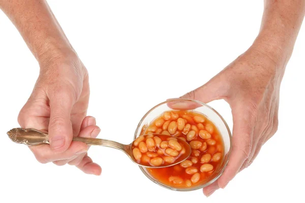 Seorang wanita tua senior mengambil sendok kacang dengan tomat sau — Stok Foto