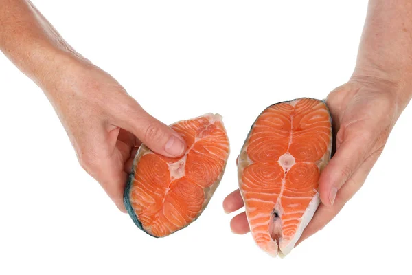 Una vecchia anziana tiene una bistecca di salmone isolate le mani — Foto Stock