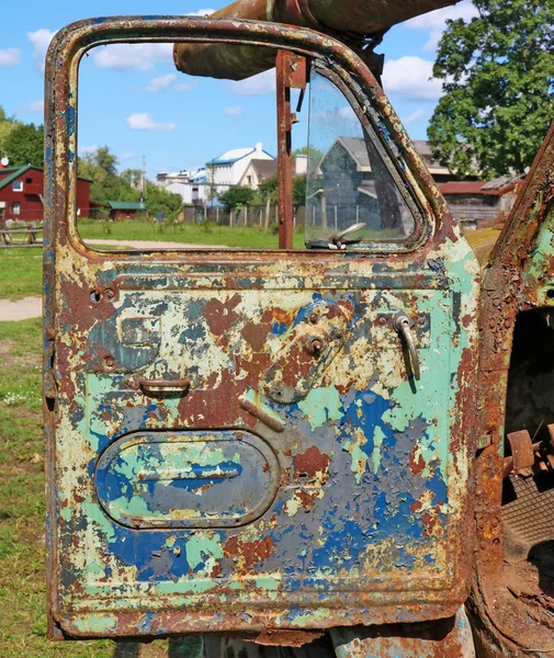 Die offene Tür eines alten rostigen landwirtschaftlichen Nutzfahrzeugs, das — Stockfoto