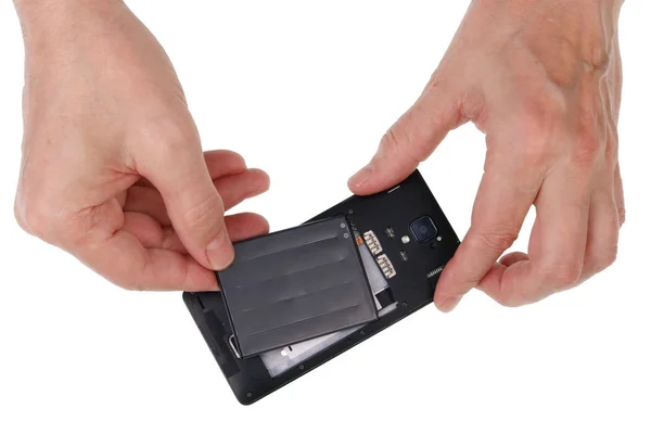 Idosos homem sênior insere bateria em um novo não nome smartphon — Fotografia de Stock