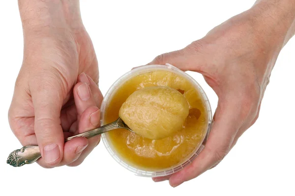 L'uomo anziano prende il miele d'estate d'oro con un cucchiaio da un piatto — Foto Stock