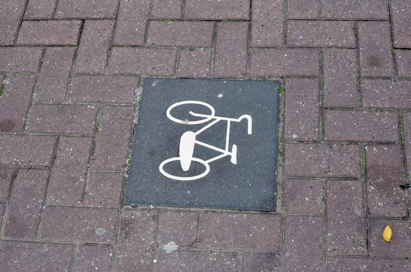 Ένα σημάδι με ένα σύμβολο ποδηλάτου βρίσκεται σε μια δημόσια διαδρομή ποδηλάτων πόλης — Φωτογραφία Αρχείου