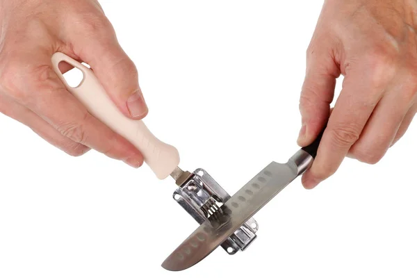 Idoso sênior afiando uma faca de cozinha em um afiador de disco — Fotografia de Stock