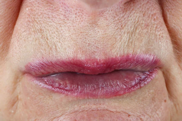 一个老年妇女紧紧挤压的粉红色嘴唇。毛孔 — 图库照片