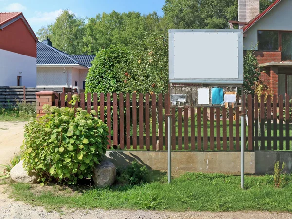 Деревенская доска новостей и объявлений установлена возле деревянного забора — стоковое фото