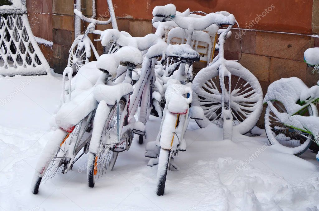 Snowy forgotten old bikes  on a winter February  street of an ol