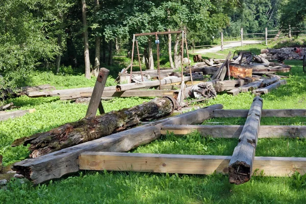 Workplace of a rural home non-professional carpenter. Sawn boards lie on a green lawn. Summer rustic landscape