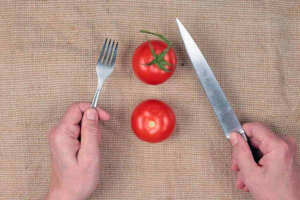老人はナイフとフォークでトマトを食べる — ストック写真