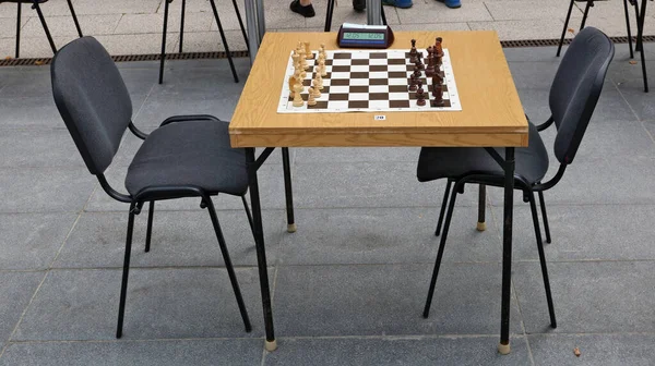 A table with a chessboard at the city tournament of chess  fans