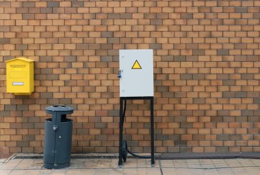 Posta kutusu, çöp kutusu ve elektrik kutusu olan tuğla duvar